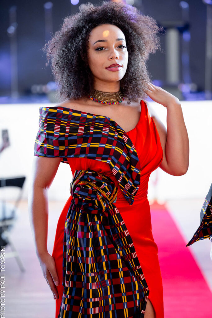 Cette robe signée Fatou Touré pour FTY Creations marie un imprimé graphique noir et blanc à un drapé rouge vif, une pièce audacieuse présentée lors du défilé Fashion for Good le 3 juillet 2026 qui illustre l'énergie et la modernité de la mode africaine contemporaine.