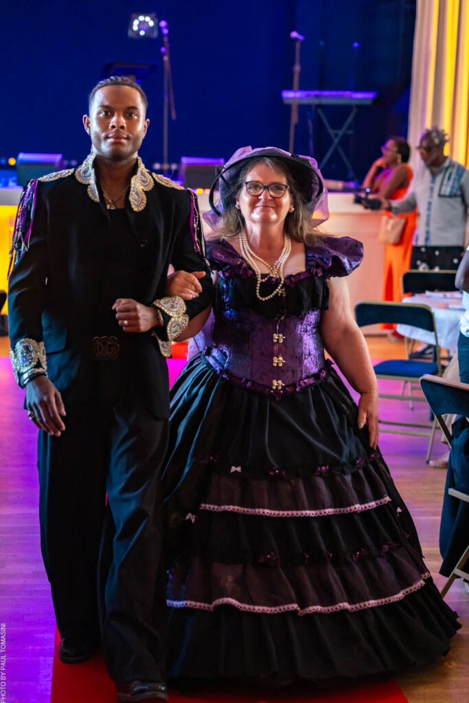 Nathalie Froufrou signe ce duo : elle, sublime dans une robe crinoline violette et noire à corset lacé et chapeau à voilette ; lui, Johann, éclatant dans un boléro noir brodé d'or façon matador.