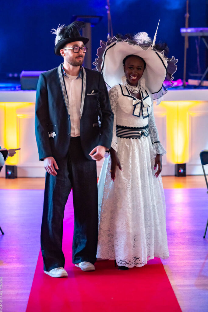 Nathalie Froufrou célèbre deux élégances d'antan : Bennou en dentelle blanche et chapeau à plumes vertigineuses, Nicolas en blazer sombre et haut-de-forme, pour un même salon Belle Époque.